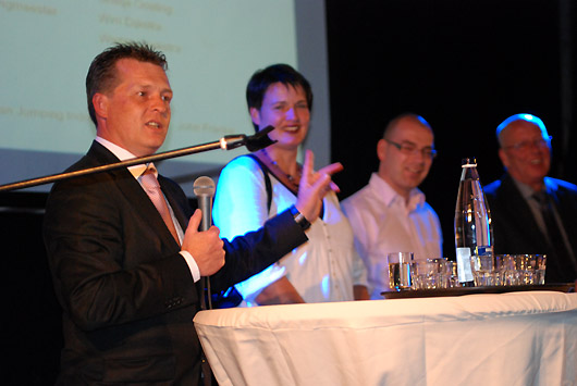 John Franke tijdens de presentatie, op de achtergrond de voorzitter Grietje Oosting. ©Steven Stegen