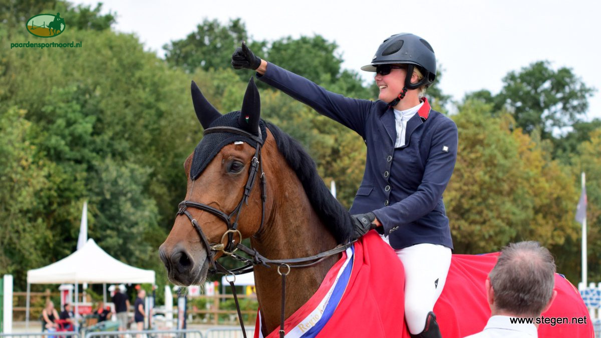 Renate Beuving steekt haar duim omhoog richting haar fans, nadat ze met Fellow Drents kampioen ZZ-springen is geworden.