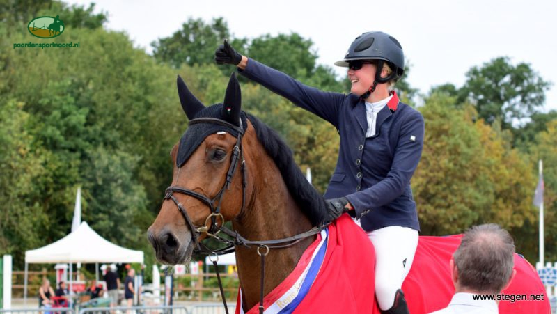 Renate Beuving steekt haar duim omhoog richting haar fans, nadat ze met Fellow Drents kampioen ZZ-springen is geworden.