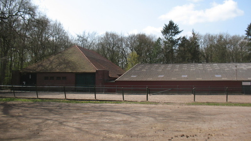 De manege in Ter Apel, met links de afgekeurde inrijhal, waarin zich pilaren bevinden.